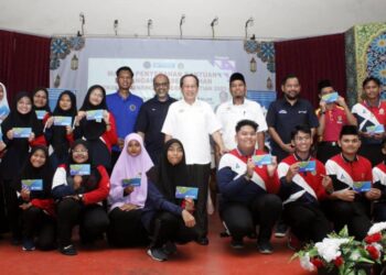 AHMAD Maslan bersama penerima bantuan persekolahan Yayasan Bank Rakyat di Pontian, Johor. - UTUSAN