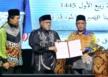 WAN Zahidi Wan Teh (tengah) menyerahkan Deklarasi Ipoh mempertahankan aliran ASWJ kepada Menteri Besar Perak, Datuk Seri Saarani Mohamad pada Muzakarah Sultan Nazrin Muizzuddin Shah di Ipoh hari ini. - UTUSAN/MUHAMAD NAZREEN SYAH MUSTHAFA