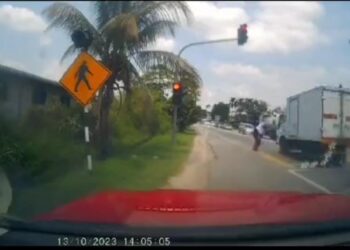 TANGKAP layar video tular seorang pelajar perempuan hampir dilanggar lori yang melanggar lampu isyarat merah ketika melintas jalan di Batu Gajah. - UTUSAN