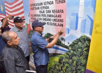 CHE Roslan Che Daud (kanan) melukis  mural sempena Program Eksplorasi Rukun Negara Peringkat Negeri Kelantan di Sekolah Kebangsaan Sri Wangi 2 di Gua Musang, Kelantan, hari ini. -UTUSAN/AIMUNI TUAN LAH