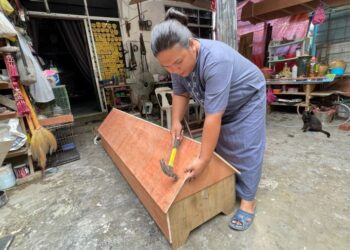 MUHAMAD Asrul Abdul Kadir menyiapkan tempahan keranda di Kampung Kastam, Alor Setar, Kedah. - UTUSAN/JAMLIAH ABDULLAH