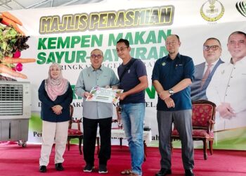 MOHD. Zolkafly Harun (dua dari kiri) menyampaikan hadiah kepada pemenang  pertandingan menanam sayur pada program Hari Ladang Daerah Larut Matang Selama di Taiping hari ini. - UTUSAN/WAT KAMAL ABAS

.