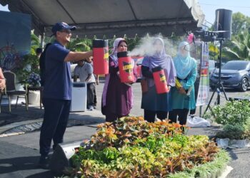 KASEMANI Embong (dua dari kanan) membuat gimik melakukan semburan aerosol pada Majlis Gotong-Royong Mega Perangi Aedes dan ‘One Hour Clean Up’ Peringkat Negeri Terengganu, Kemaman, hari ini. - UTUSAN/NIK NUR IZZATUL HAZWANI NIK ADNAN