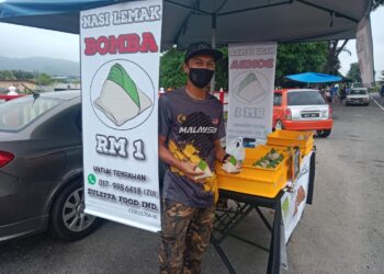 ZULKIFLI Nordin bersama nasi lemak menggunakan beras import dijual RM1 berdekatan Balai Bomba Jerantut, Pahang. - UTUSAN/HARIS FADILAH AHMAD