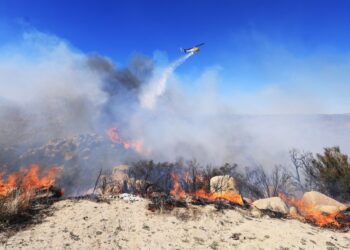 HELIKOPTER bomba mengugurkan air di kawasan kebakaran hutan di Aguana, California. - AFP