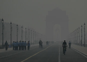 PENDUDUK berjalan dalam keadaan kabus di India Gate, New Delhi. - AFP