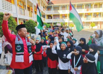 RATUSAN murid berkumpul bagi menyatakan pendirian menentang keganasan dalam kempen kemanusiaan Palestin di SK Guar Jentik, Padang Besar, Perlis, semalam. -UTUSAN/SYED AZLAN SAYID HIZAR