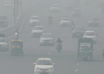 PENDUDUK memandu dalam keadaan kabus tebal di New Delhi. - AFP