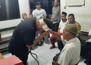 LELAKI yang cedera (kiri) bersalaman dengan bapanya ketika proses mediasi di Balai Polis Daerah Sandubaya di Mataram, Nusa Tenggara Barat.-AGENSI