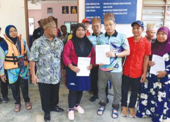 NIK Nazmi Nik Ahmad (tiga kanan) semasa menerima serahan memorandum di pusat Rancangan Pengumpulan Semula (RPS) Kuala Betis, Gua Musang, Kelantan, kelmarin. -UTUSAN/KAMARUL BISMI KAMARUZAMAN