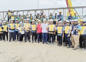 HAMEED MYTHEEN Kunju Basheer (lima dari kanan) bersama kakitangan JKR menunjukkan isyarat bagus di tapak pembinaan jambatan sementara di Kampung Setulang Daeng, Klebang, Melaka. - UTUSAN/AMRAN MULUP