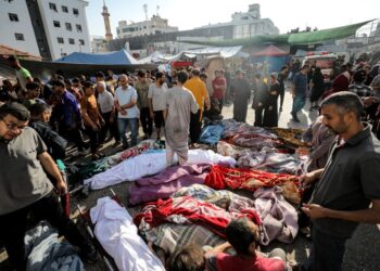 PENDUDUK Palestin memeriksa mayat mangsa yang bergelimpangan di luar Hospital al-Shifa di Gaza City.-AFP