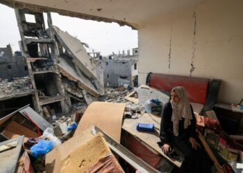 SEORANG wanita Palestin duduk di atas serpihan runtuhan di apartmennya yang rosak di daerah Khezaa di selatan Genting Gaza.-AFP