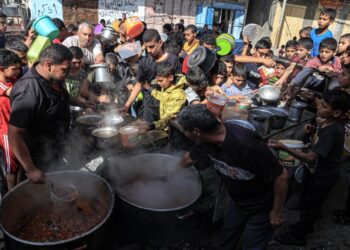 RAKYAT Palestin beratur untuk menerima makanan di dapur amal sementara di Rafah di selatan Semenanjung Gaza.-AFP