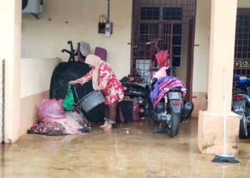 SEORANG mangsa banjir mengemas rumahnya yang dinaiki air dalam kejadian banjir di Taman Seri Intan, Kuala Besut, Besut, semalam. - UTUSAN/WAN ZURATIKAH IFFAH WAN ZULKIFLI   