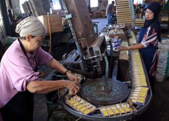 DUA pekerja wanita tempatan memasukkan batang-batang mancis secara manual ke dalam kotak mancis cap lada keluaran syarikat Kelantan Match Factory di Sungai Keladi, Kota Bharu, Kelantan, semalam. - UTUSAN/KAMARUL BISMI KAMARUZAMAN