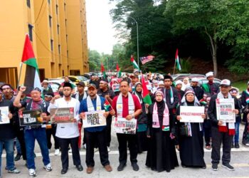 SUHAIZAN KAYAT (tengah) memegang sepanduk dan berarak bersama-sama penduduk dalam Himpunan Aman Solidariti Program Perumahan Rakyat (PPR) Kempas Permai Prihatin Palestin di Johor Bahru.