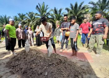 EHMAD HADIE ELFARDIE menyiram kubur bapanya, Mohd. Suhaimi di Tanah Perkuburan Islam Felcra Sungai Ara, Kota Tinggi.