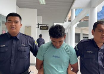 TERTUDUH diiring keluar anggota polis selepas mengaku bersalah di Mahkamah Majistret, Ayer Keroh, Melaka atas pertuduhan merakam isteri jirannya sedang mandi.