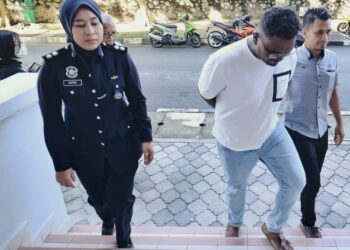 P. MANIMARAN (tengah) dibawa ke Mahkamah Majistret Seremban hari ini bagi didakwa atas pertuduhan bermain mercun hingga membahayakan nyawa dan merosakkan harta awam pada Jumaat lalu.-UTUSAN/MOHD. SHAHJEHAN MAAMIN.