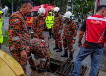 OPERASI SAR masih berjalan di dalam longkang di Jalan Bukit Baru, Bukit Palah, Melaka. - UTUSAN/SYAFEEQ AHMAD