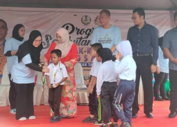 NOR Tipah Majin (empat dari kiri) pada majlis penyampaian pingat kepada murid sekolah yang menyertai Sambutan Hari Kanak-Kanak Kebangsaan Peringkat Negeri Perak di Sekolah Kebangsaan Sungai Tinggi di Bukit Gantang hari ini. - UTUSAN/WAT KAMAL ABAS