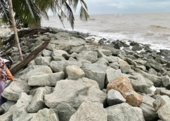 RAJA Mariam Raja Awang melihat keadaan ombak yang agak kuat menghempas di Pantai Dasar Sabak, Kota Bharu, Kelantan semalam. - UTUSAN/ROSLIZA MOHAMED