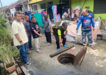 PENDUDUK menunjukkan pembentung di perumahan Taman Bandar Baru Kuantan Putri, Sungai Soi  yang mula dilimpahi air loji kumbahan sebelum  mengeluarkan bau busuk. – UTUSAN/NORHAFIZAN ZULKIFLI