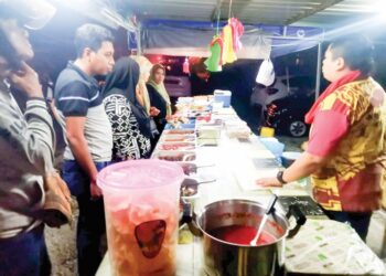 PELANGGAN membeli makanan di gerai yang dibuka mulai tengah malam di Kampung Bahagia, Teluk Intan, Perak. - UTUSAN/AIN SAFRE BIDIN