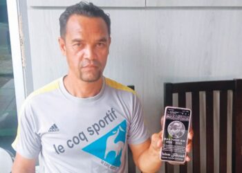 ISMAIL Beharom menunjukkan gambar anaknya dalam telefon bimbit ketika ditemui di rumahnya di Taman Seri Delima, Seri Manjung. - UTUSAN/SHAMSUL KAMAL AMARUDIN