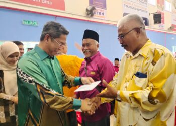 JALALUDDIN Alias (kiri) menyampaikan tunggakan elaun kepada sebahagian pengerusi dan setiausaha Jawatankuasa Pembangunan dan Keselamatan Kampung Persekutuan (JPKKP) Negeri Sembilan di Rembau hari ini.-UTUSAN/NOR AINNA HAMZAH.