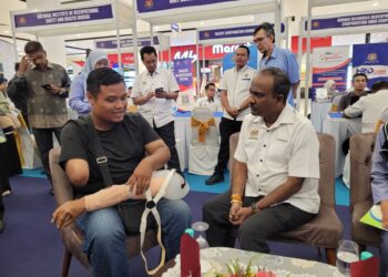 SIVAKUMAR (kanan) sempat berbual mesra dengan Mohamad Aminuddin pada program Hari Bertemu Pelanggan Kementerian Sumber Manusia Peringkat Negeri Kelantan di Tunjong, Kota Bharu, Kelantan hari ini. UTUSAN/MUSTAQIM MOHAMED.