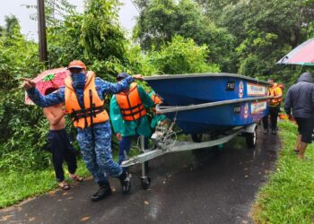 ANGGOTA pasukan penyelamat bersiap sedia menggunakan bot untuk membawa keluar penduduk Kampung Tok Kundur, Pasir Puteh, Kelantan, hari ini.UTUSAN/TOREK SULONG.