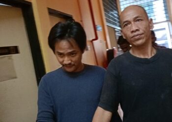 MOHAMAD Hafiz Naharoddin (kiri) dibawa ke Mahkamah Sesyen Teluk Intan hari ini atas tuduhan cuba membunuh anggota polis.