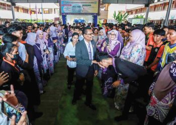 M. Magendran (tengah) bersalaman dengan warga guru dan murid SMK Taman Sri Muda, Shah Alam, Selangor pada majlis persaraannya semalam. – Utusan/AFIQ RAZALI