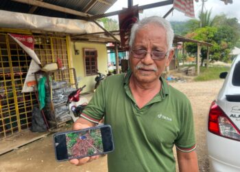 CHE Sulaiman Che Kob menunjukkan pakaian mangsa yang dibaham harimau belang di Kampung Kuala Tol, Gua Musang, Kelantan.UTUSAN/AIMUNI TUAN LAH