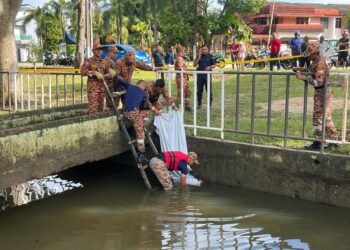 ANGGOTA bomba mengangkat mayat Muhammad Danish Mohd. Faizal yang ditemui terapung dalam longkang besar di Taman Desa Baru, Melaka. - UTUSAN/AMRAN MULUP