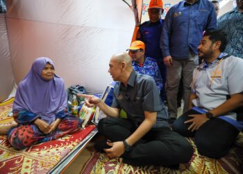 ARMIZAN Mohd. Ali (dua, kiri) menyantuni mangsa banjir semasa melawat PPS SK Atas Tol, Kuala Terengganu, hari ini. - UTUSAN/PUQTRA HAIRRY ROSLI