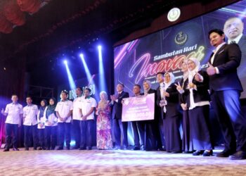 SAARANI Mohamad (tengah) menyampaikan hadiah pemenang utama Anugerah Inovasi Menteri Besar kepada Pusat Penyelidikan Mineral, Jabatan Mineral dan Geosains Malaysia di Ipoh hari ini. - UTUSAN/MUHAMAD NAZREEN SYAH MUSTHAFA