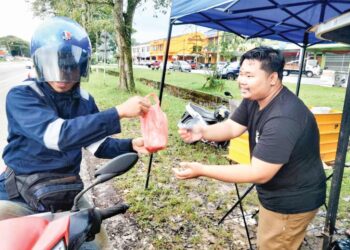 MIOR Usman Mior Ishak melayan seorang pelanggan yang membeli nasi lemak RM1 di gerainya di hadapan Taman Pontian Utama, Jalan Pontian-Johor Bahru.