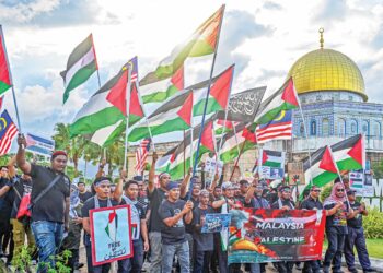 LEBIH 100 kakitangan Taman Tamadun Islam (TTI) berhimpun berlatarkan monumen 'Dome of the Rock' bagi menyatakan solidariti terhadap rakyat Palestin di Kuala Terengganu, semalam.  – UTUSAN/PUQTRA HAIRRY