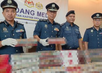 ABDUL Ghafar Mohamad  (dua dari kiri) menunjukkan rokok putih dan kretek yang dirampas dalam dua serbuan berasingan di Pantai Remis dan Sitiawan minggu lalu. - UTUSAN