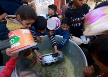 KANAK-KANAK Palestin mengambil makanan di pusat derma di Rafah, selatan Semenanjung Gaza. - AFP