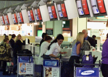 PENUMPANG mendaftar masuk di Terminal Lapangan Terbang Antarabangsa Sydney, Australia. - AFP