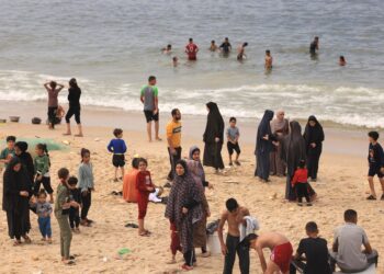 PENDUDUK Palestin mandi dan mencuci baju di tepi pantai akibat kekurangan bekalan air bersih di Deir al-Balah, Semenanjung Gaza. - AFP