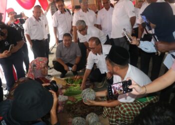 WAN Rosdy Wan Ismail (tengah) bertanyakan harga produk pertanian yang dijual di Pekan Sehari Temerloh di Lurah Semantan, Pahang yang diiktiraf sebagai pekan sehari terpanjang dengan jumlah peniaga terbesar di Malaysia oleh Malaysia Book Of Records.