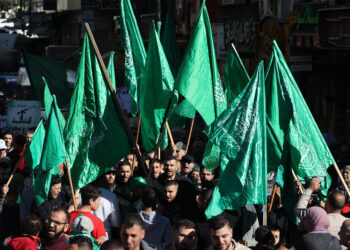 PENDUDUK Palestin membawa bendera Hamas ketika melakukan protes menentang serangan tentera Israel di Semenanjung Gaza di Ramallah, Tebing Barat. - AFP