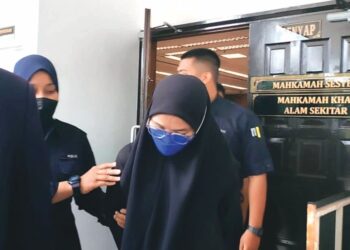 MASANIZAH Roslan diiring anggota polis di Mahkamah Sesyen, Ayer Keroh, Melaka.