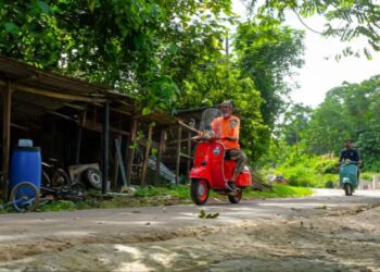 RAHIM Amat menunggang motosikal klasik jenis Vespa yang sudah berusia 50 tahun ketika ditemui di rumahnya di Kampung Pulau Sebang, Alor Gajah, Melaka. - UTUSAN/SYAFEEQ AHMAD