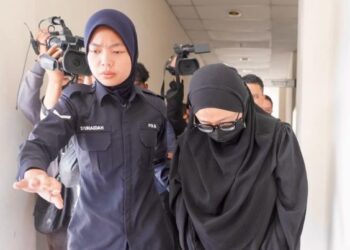 NUR Sari Fardiana Mohd. Amran dibawa oleh anggota polis ke Mahkamah Sesyen Petaling Jaya bagi menghadapi pertuduhan mengabai anak perempuannya dalam kereta. - UTUSAN/SHIDDIEQIIN ZON